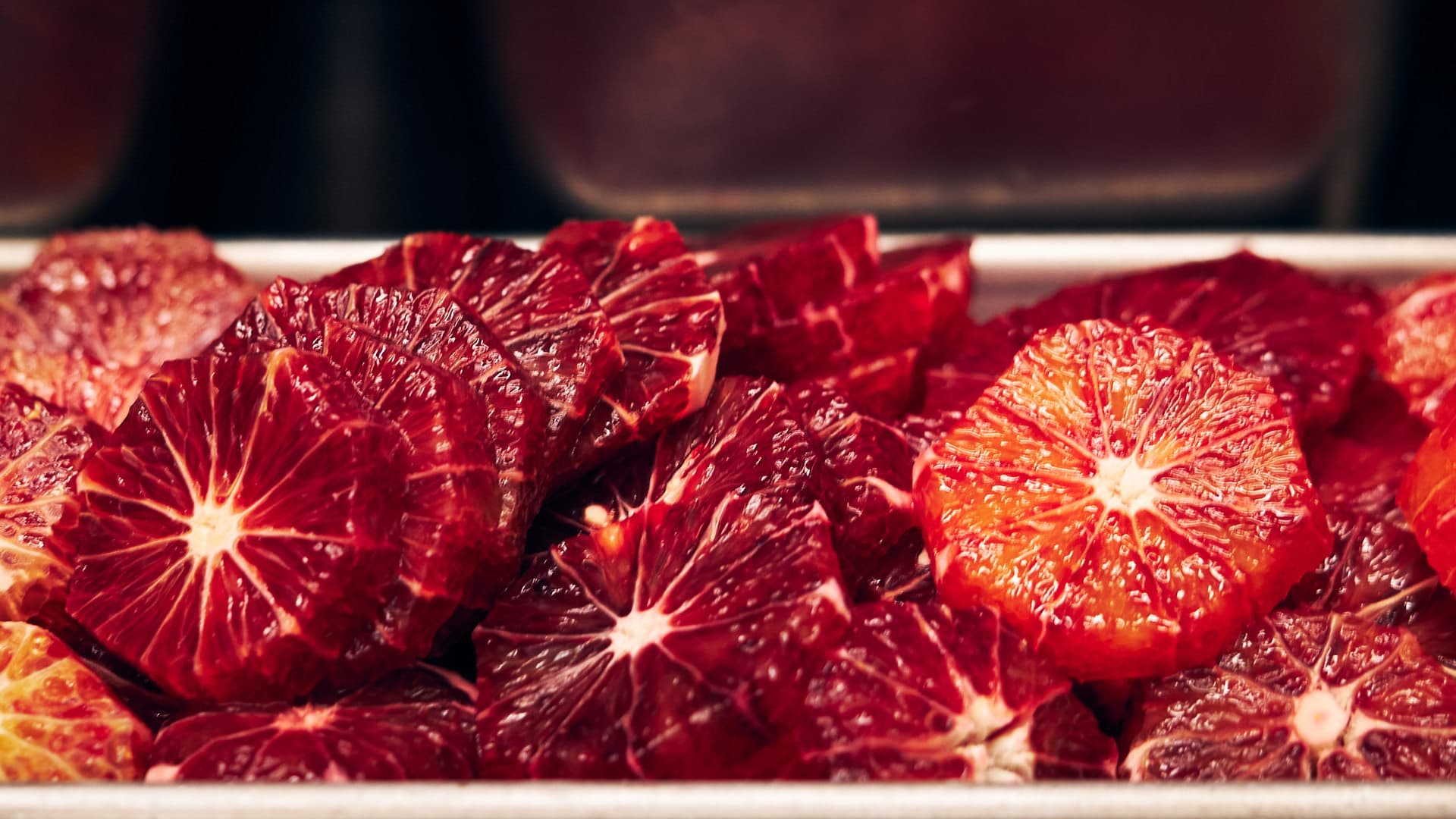 Close-up of sliced blood oranges in a kitchen tray, photographed by MDDA